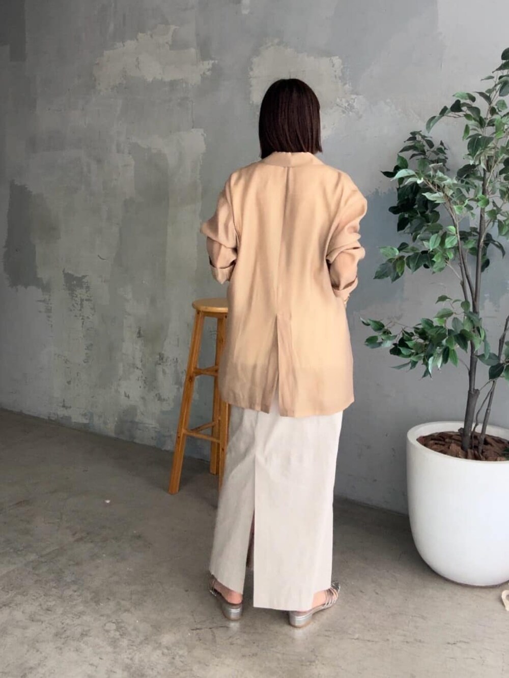 ブラック系のテーラードジャケット、ホワイト系のニット/セーター、ベージュ系のスカートを着用したレディースの春コーディネートの3枚目の写真