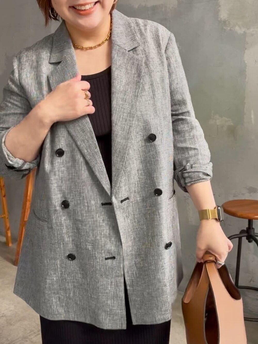 ブラック系のテーラードジャケット、ブラック系のワンピース、ブラック系のパンプスを着用したレディースの冬コーディネートの3枚目の写真