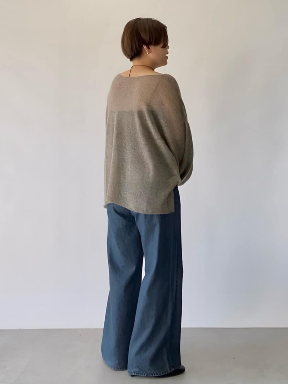 ブラウン系のニット/セーター、ブルー系のデニムパンツ、ブラック系のネックレスを着用したレディースの秋コーディネートの3枚目の写真