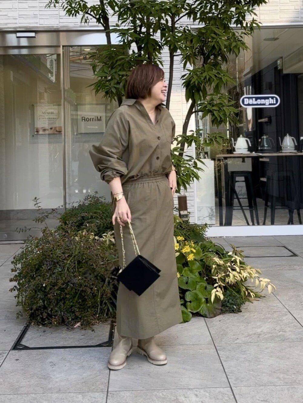 ベージュ系のシャツ/ブラウス、ベージュ系のスカート、ブラック系のショルダーバッグを着用したレディースの冬コーディネートの2枚目の写真