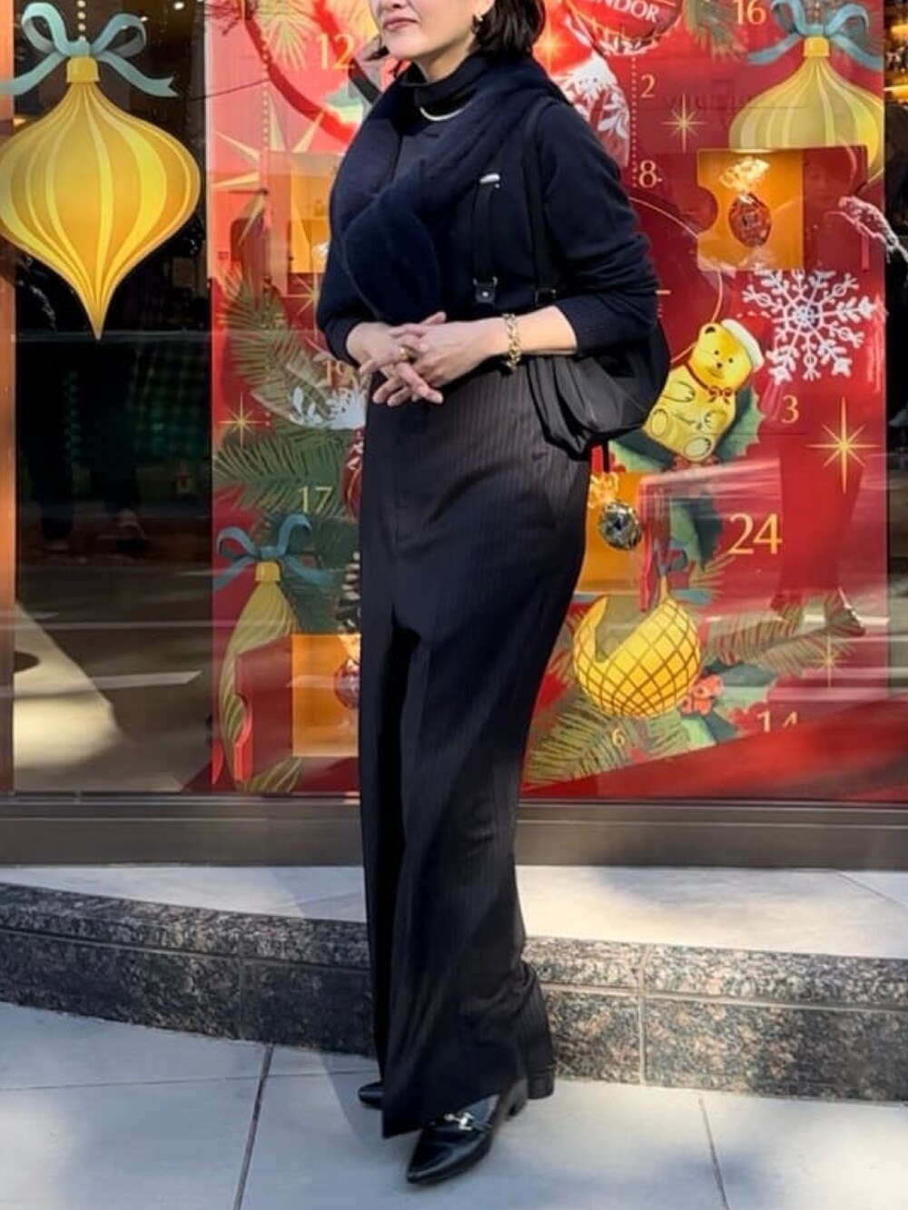 ブルー系のニット/セーター、ブラック系のスラックス、ブラック系のローファーを着用したレディースの冬コーディネートの3枚目の写真