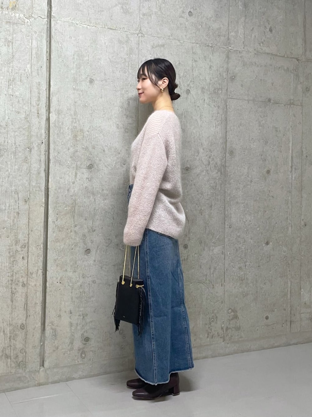 ピンク系のニット/セーター、ブルー系のデニムスカート、ブラウン系のブーツを着用したレディースの秋コーディネートの2枚目の写真