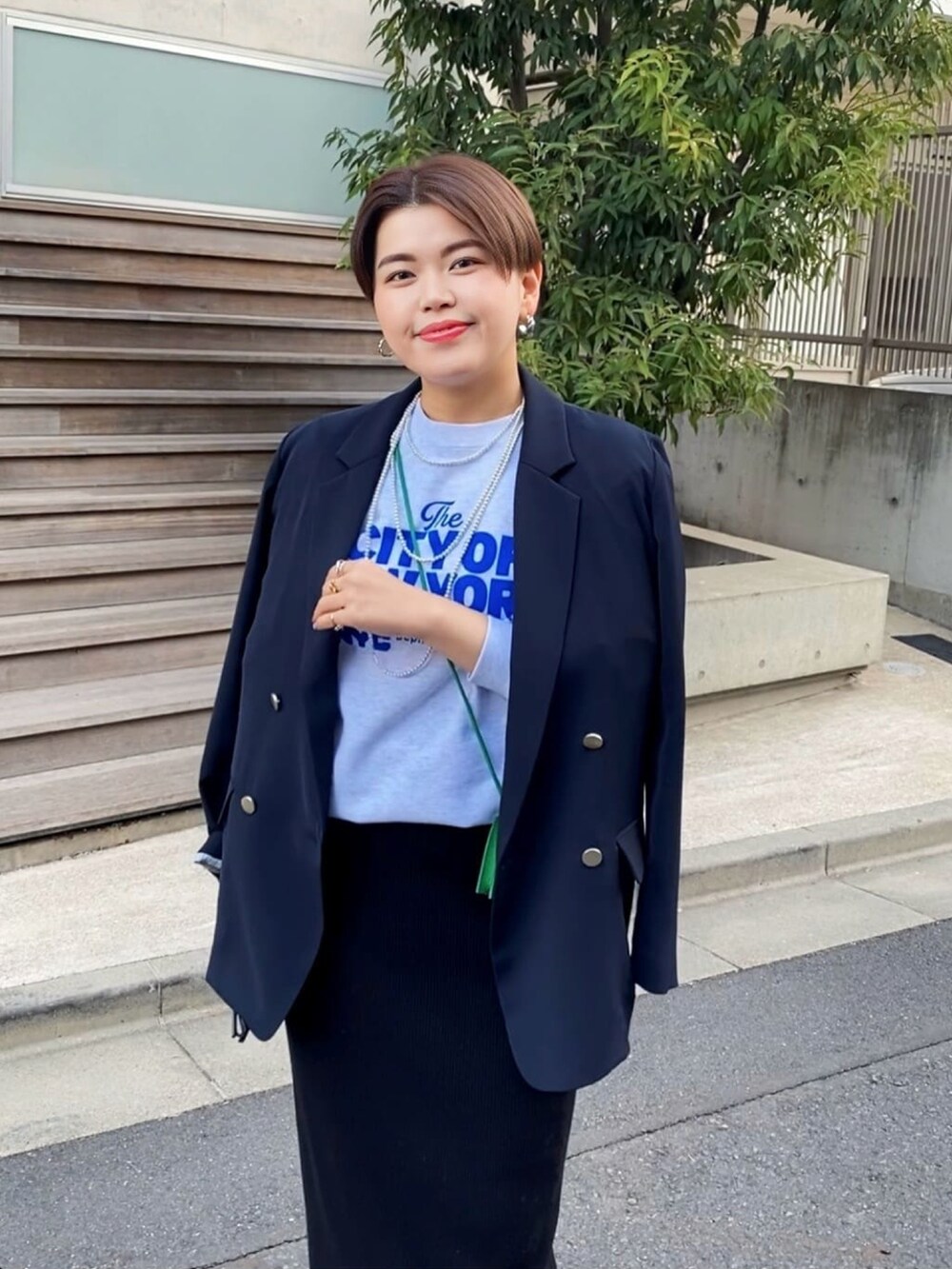 グレー系のスウェット、ベージュ系のテーラードジャケット、ブラック系のスカートを着用したレディースの冬コーディネートの3枚目の写真