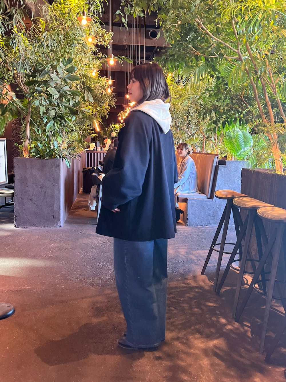 ブルー系のピーコート、ブルー系のデニムパンツ、グレー系のパーカーを着用したレディースの冬コーディネートの2枚目の写真