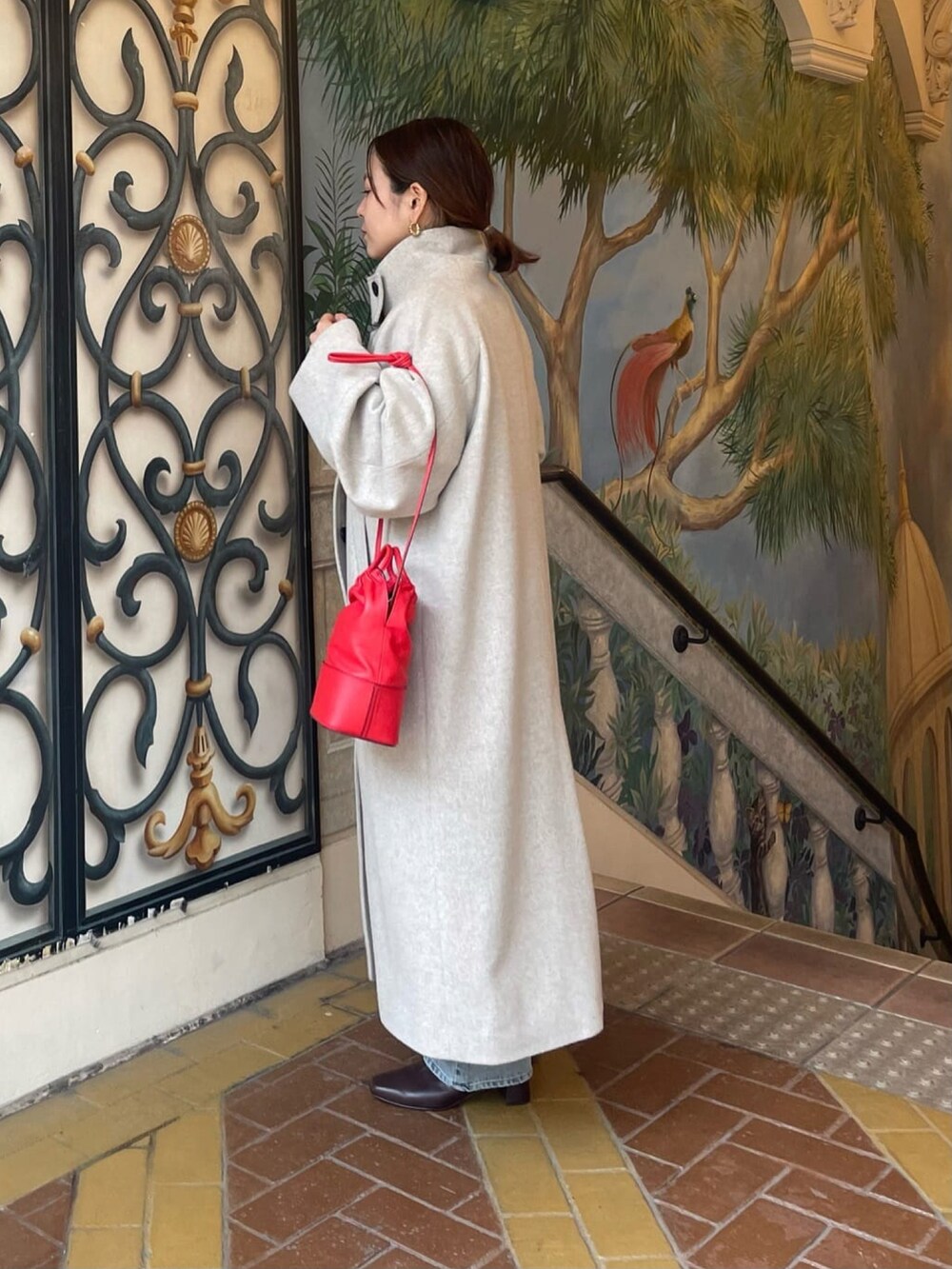 ブルー系のデニムパンツ、ブラウン系のブーツ、ブラウン系のニット/セーターを着用したレディースの冬コーディネートの3枚目の写真