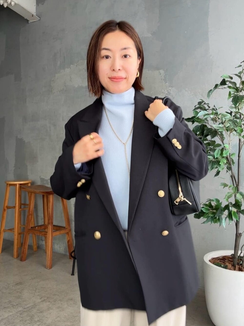 ブルー系のニット/セーター、ブルー系のテーラードジャケット、ベージュ系のその他パンツを着用したレディースの秋コーディネートの5枚目の写真