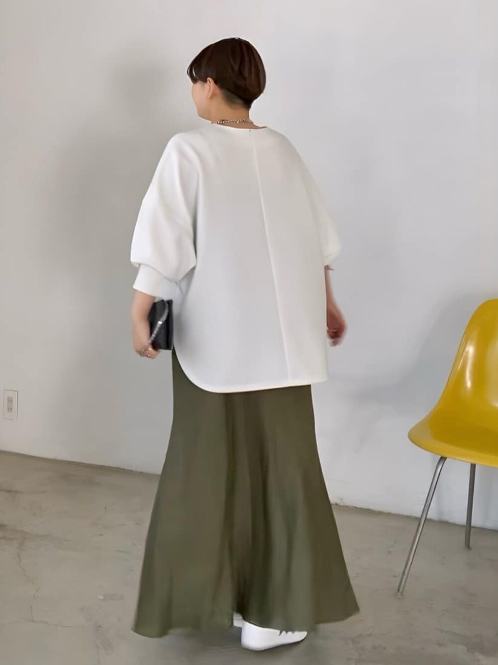 ホワイト系のTシャツ/カットソー、グリーン系のスカート、ブラック系のショルダーバッグを着用したレディースの春コーディネートの2枚目の写真