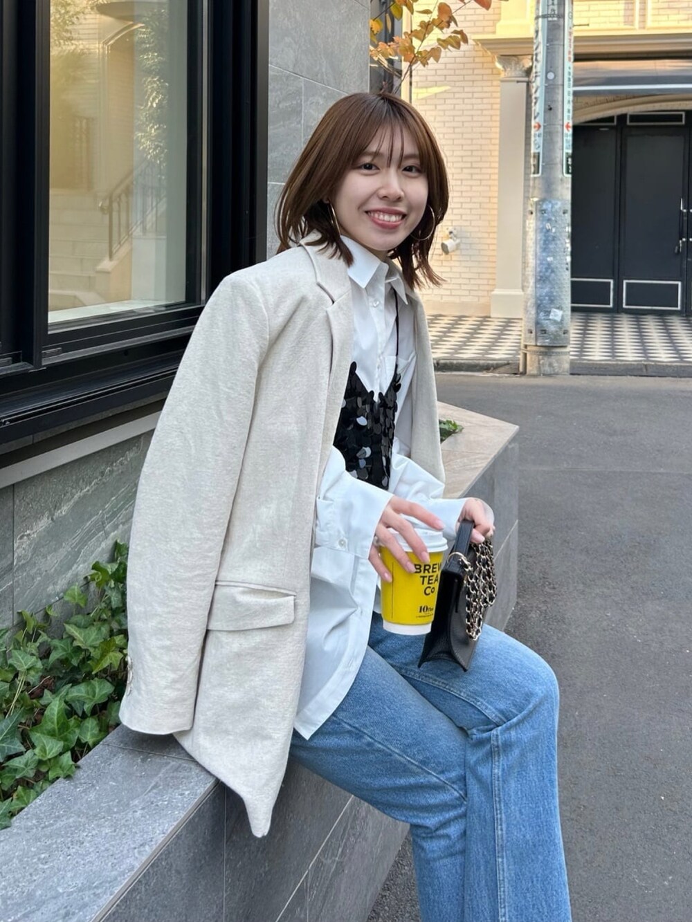 ホワイト系のシャツ/ブラウス、ベージュ系のテーラードジャケット、ブラック系のキャミソールを着用したレディースの冬コーディネートの3枚目の写真