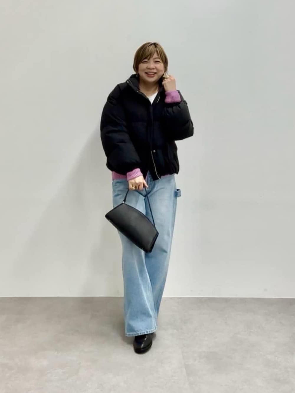 ブラック系のハンドバッグ、ブラック系のダウンジャケット/コート、ピンク系のカーディガン/ボレロを着用したレディースの秋コーディネートの3枚目の写真