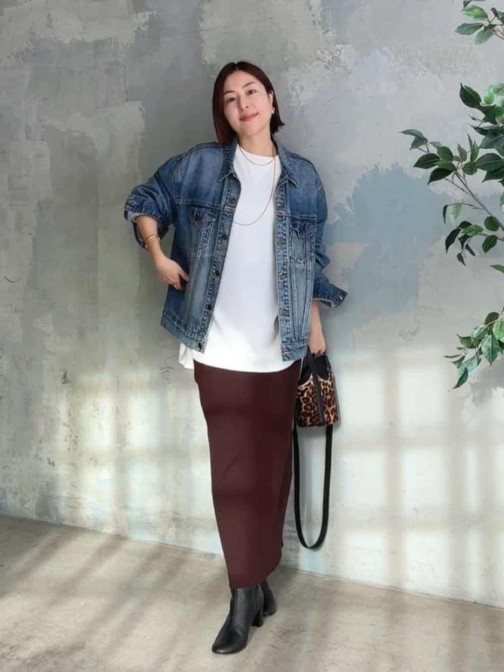 ブルー系のデニムジャケット、ホワイト系のTシャツ/カットソー、ブラック系のブーツを着用したレディースの冬コーディネートの4枚目の写真