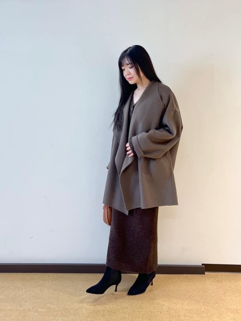 ブラウン系のその他アウター、ブラウン系のカーディガン/ボレロ、ブラウン系のスカートを着用したレディースの冬コーディネートの2枚目の写真