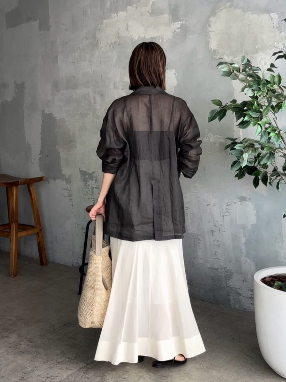 ブラック系のテーラードジャケット、ブラック系のキャミソール、ベージュ系のスカートを着用したレディースの夏コーディネートの3枚目の写真