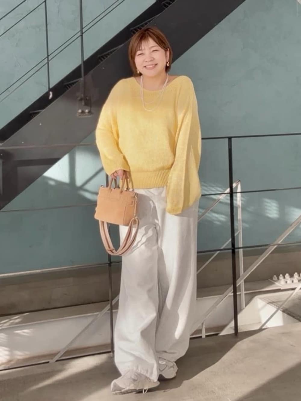 ベージュ系のトートバッグ、グレー系のスウェットパンツ、イエロー系のニット/セーターを着用したレディースの春コーディネートの3枚目の写真