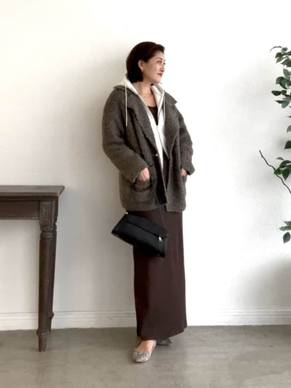 ホワイト系のパーカー、グレー系のパンプス、ブラウン系のワンピースを着用したレディースの冬コーディネートの2枚目の写真