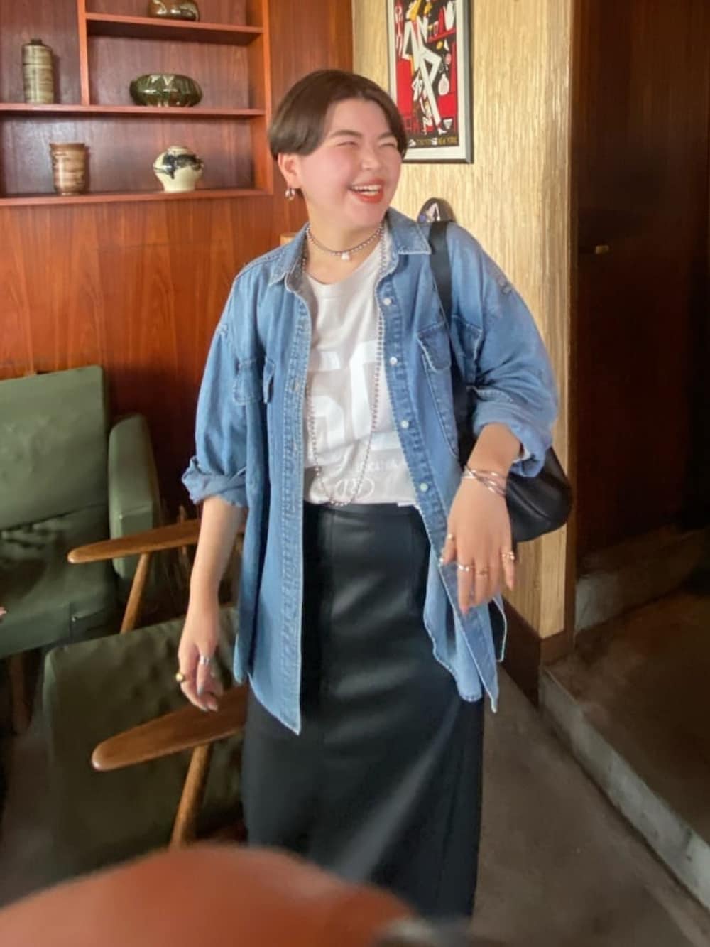 グレー系のTシャツ/カットソー、ブラック系のスカート、ブルー系のシャツ/ブラウスを着用したレディースの秋コーディネートの2枚目の写真