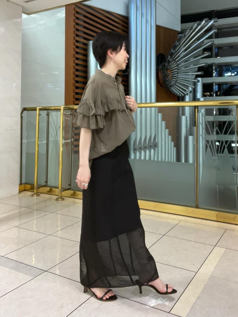 グリーン系のシャツ/ブラウス、ブラック系のショルダーバッグ、ブラック系のサンダルを着用したレディースの夏コーディネートの2枚目の写真