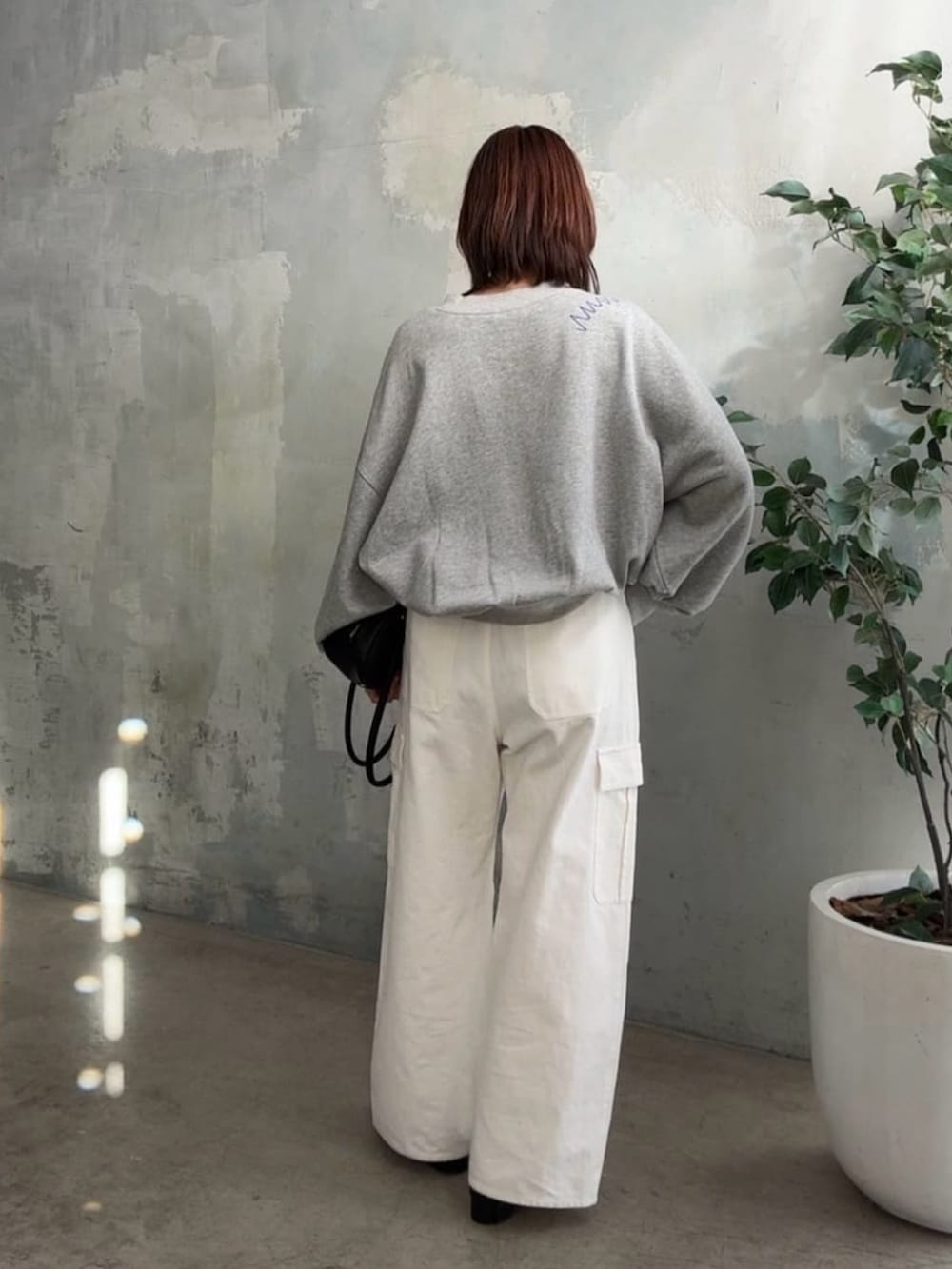 グレー系のTシャツ/カットソー、ホワイト系のカーゴパンツ、ブラック系のパンプスを着用したレディースの冬コーディネートの3枚目の写真