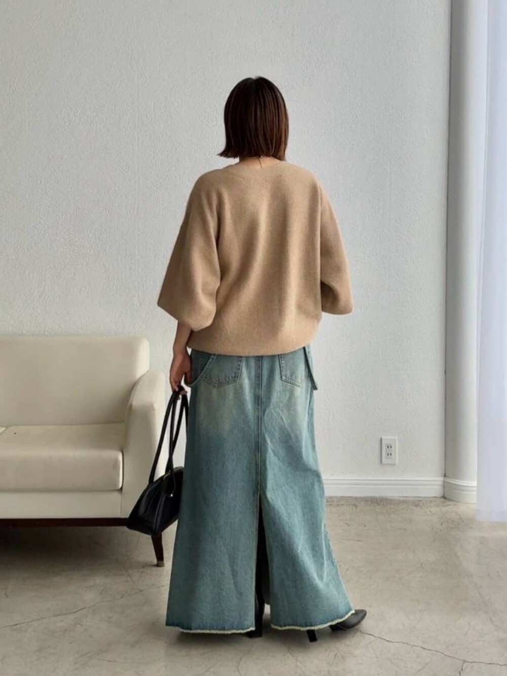 ベージュ系のカーディガン/ボレロ、ブルー系のデニムスカート、ブラック系のショルダーバッグを着用したレディースの秋コーディネートの3枚目の写真