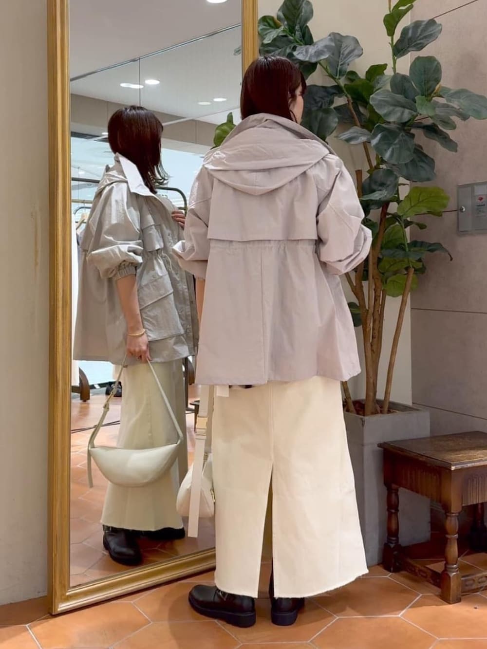 ホワイト系のシャツ/ブラウス、グレー系のマウンテンパーカー、ホワイト系のデニムスカートを着用したレディースの冬コーディネートの3枚目の写真