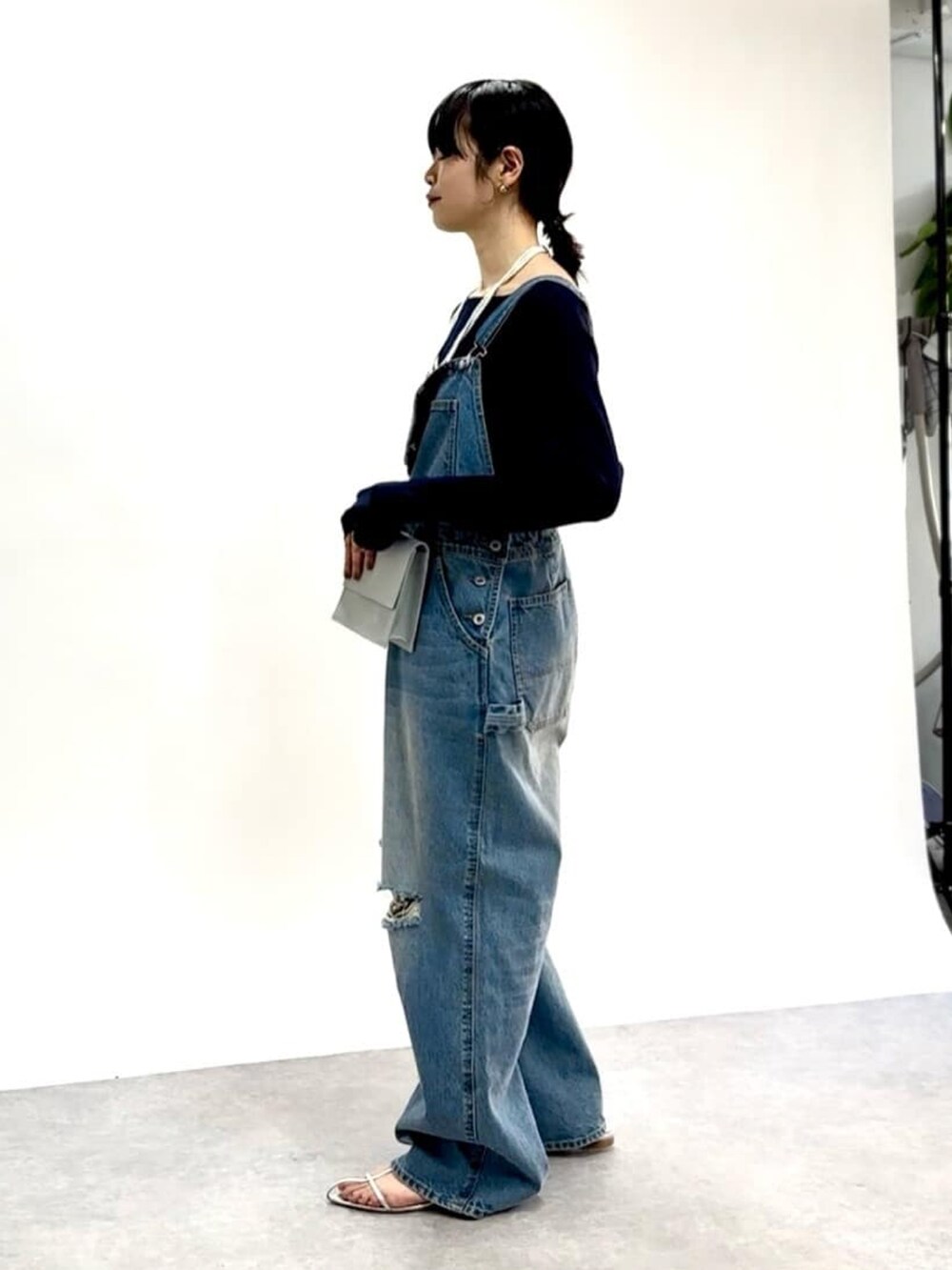 ブルー系のニット/セーター、ブルー系のサロペット/オーバーオール、ブルー系のショルダーバッグを着用したレディースの春コーディネートの2枚目の写真