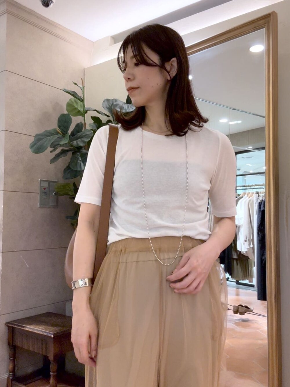 ホワイト系のTシャツ/カットソー、ブラウン系のボディバッグ/ウエストポーチ、ベージュ系のその他パンツを着用したレディースの夏コーディネートの2枚目の写真