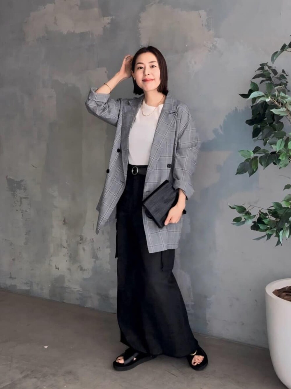 グレー系のテーラードジャケット、ブルー系のデニムスカート、ベージュ系のパーカーを着用したレディースの春コーディネートの2枚目の写真