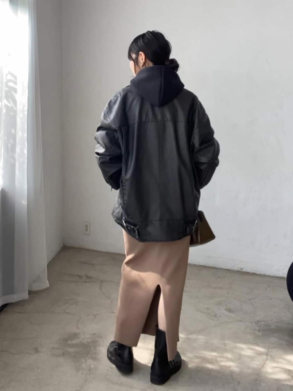 ブラック系のブルゾン、ブラウン系のスカート、ブラック系のショルダーバッグを着用したレディースの夏コーディネートの3枚目の写真