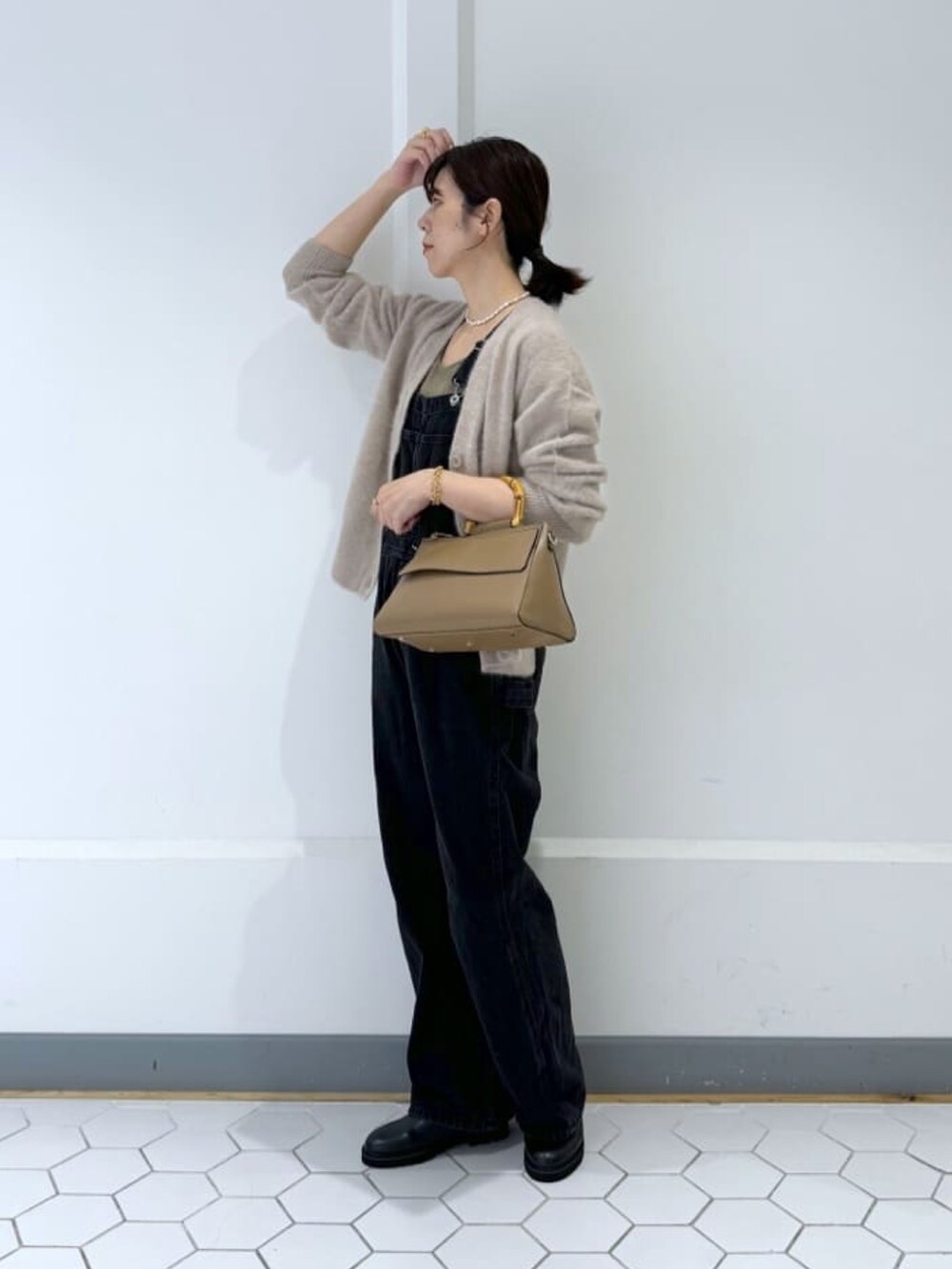 グレー系のカーディガン/ボレロ、ブラック系のサロペット/オーバーオールを着用したレディースの冬コーディネートの2枚目の写真