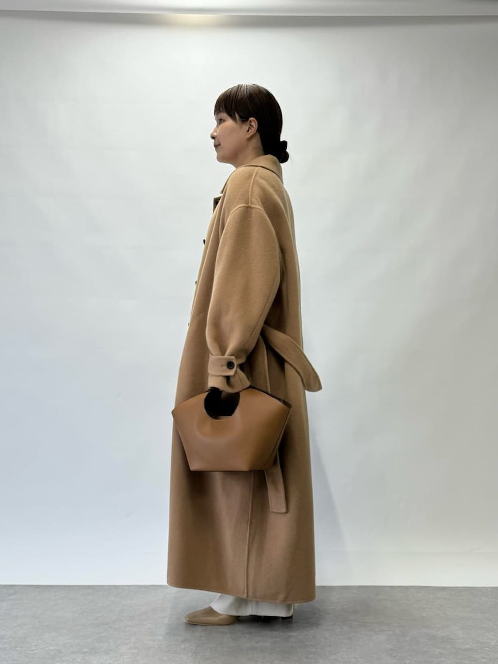 ブラウン系のニット/セーター、イエロー系のその他アウター、シルバー系のチョーカーを着用したレディースの秋コーディネートの3枚目の写真