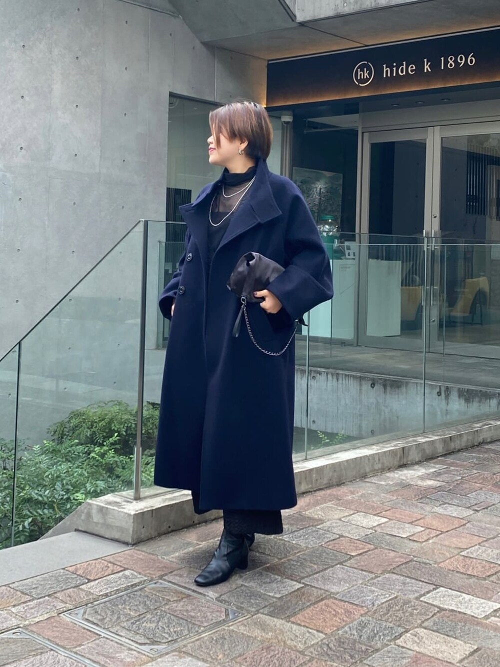 ブルー系のその他アウター、ブラック系のブーツを着用したレディースの冬コーディネートの2枚目の写真