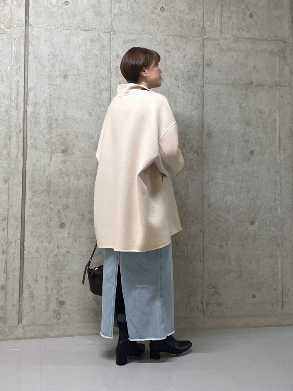 ベージュ系のその他アウター、ブルー系のデニムスカート、グレー系のニット/セーターを着用したレディースの冬コーディネートの3枚目の写真