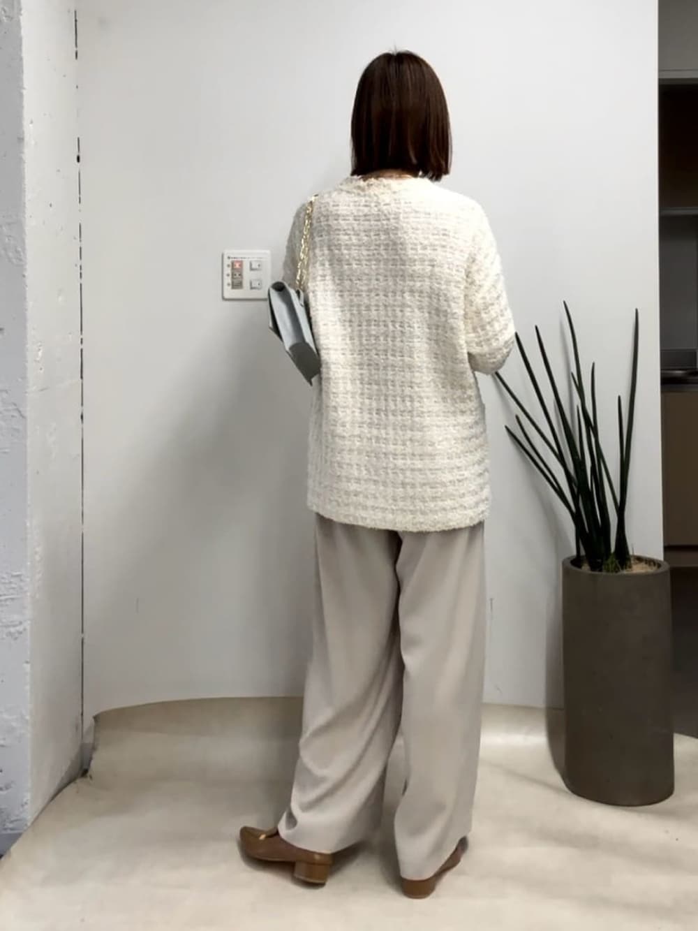 ホワイト系のカーディガン/ボレロ、グレー系のスラックス、ベージュ系のローファーを着用したレディースの冬コーディネートの3枚目の写真