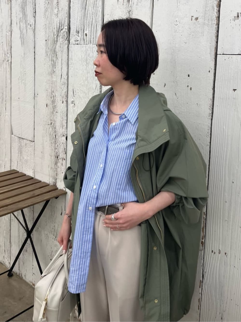 ホワイト系のボストンバッグ、ブルー系のシャツ/ブラウス、グリーン系のその他アウターを着用したレディースの春コーディネートの4枚目の写真