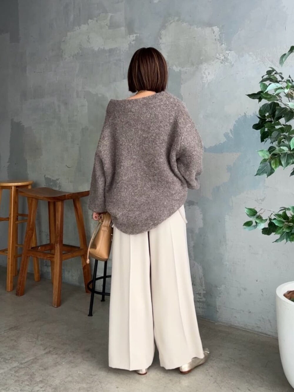 ブラウン系のニット/セーター、ベージュ系のパンツ、イエロー系のハンドバッグを着用したレディースの秋コーディネートの3枚目の写真