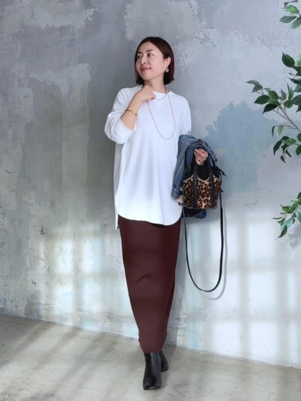 ブルー系のデニムジャケット、ホワイト系のTシャツ/カットソー、ブラック系のブーツを着用したレディースの冬コーディネートの5枚目の写真