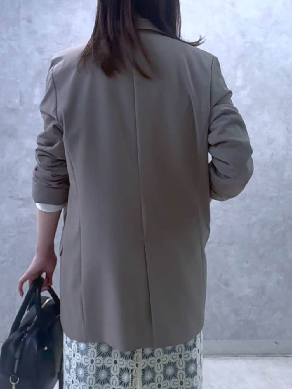 ホワイト系のスウェット、ブラウン系のテーラードジャケット、ブラック系のボストンバッグを着用したレディースの冬コーディネートの8枚目の写真