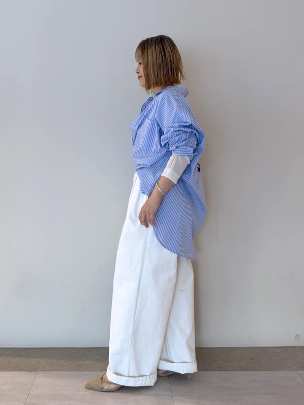 ベージュ系のパンプス、ホワイト系のTシャツ/カットソー、ホワイト系のデニムパンツを着用したレディースの冬コーディネートの2枚目の写真