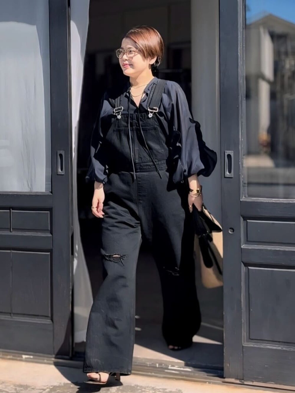 ブルー系のサロペット/オーバーオール、ブルー系のシャツ/ブラウス、ブラウン系のメガネを着用したレディースの春コーディネートの2枚目の写真