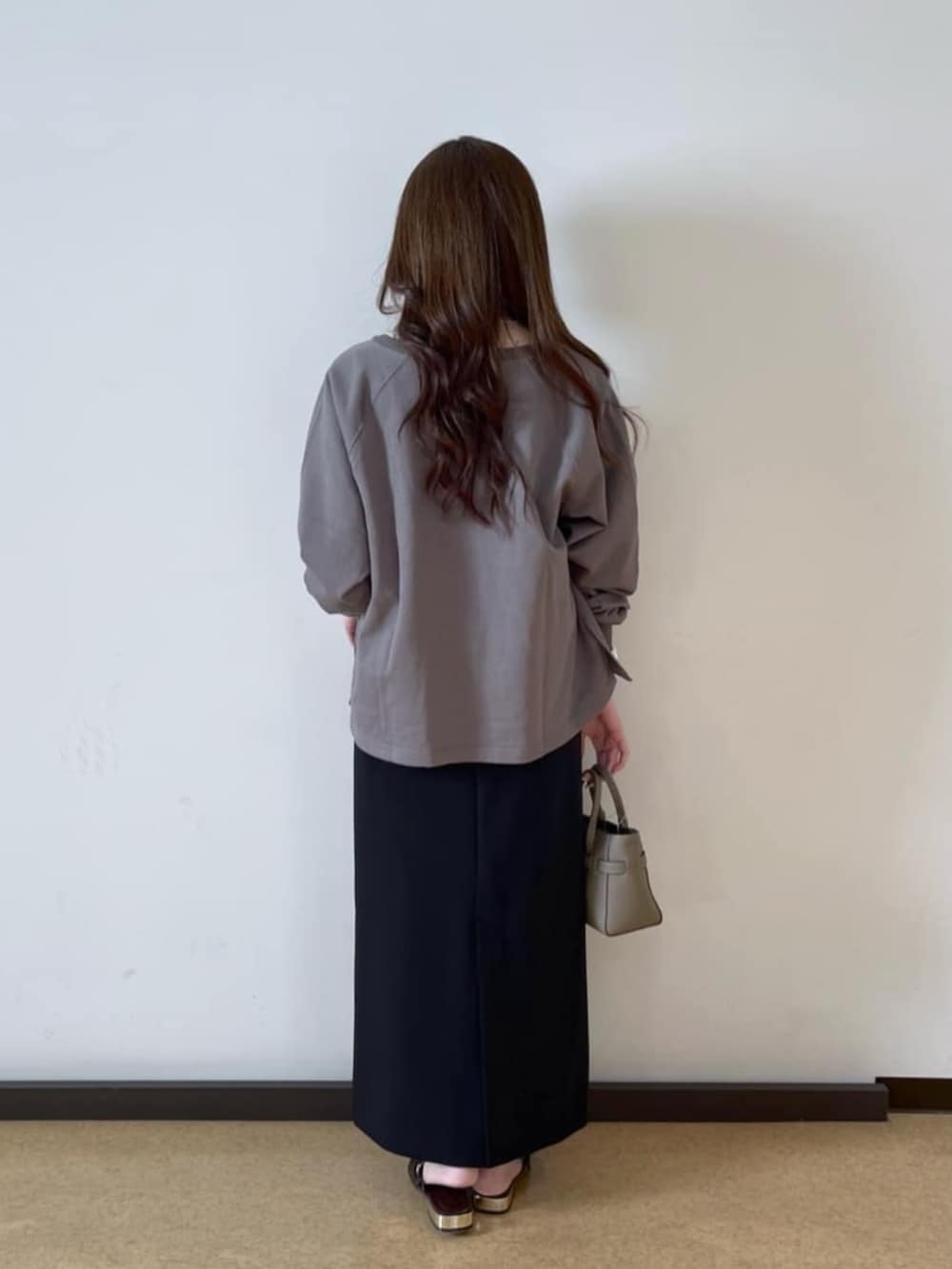 グレー系のトートバッグ、ブラウン系のその他シューズ、ホワイト系のTシャツ/カットソーを着用したレディースの春コーディネートの3枚目の写真