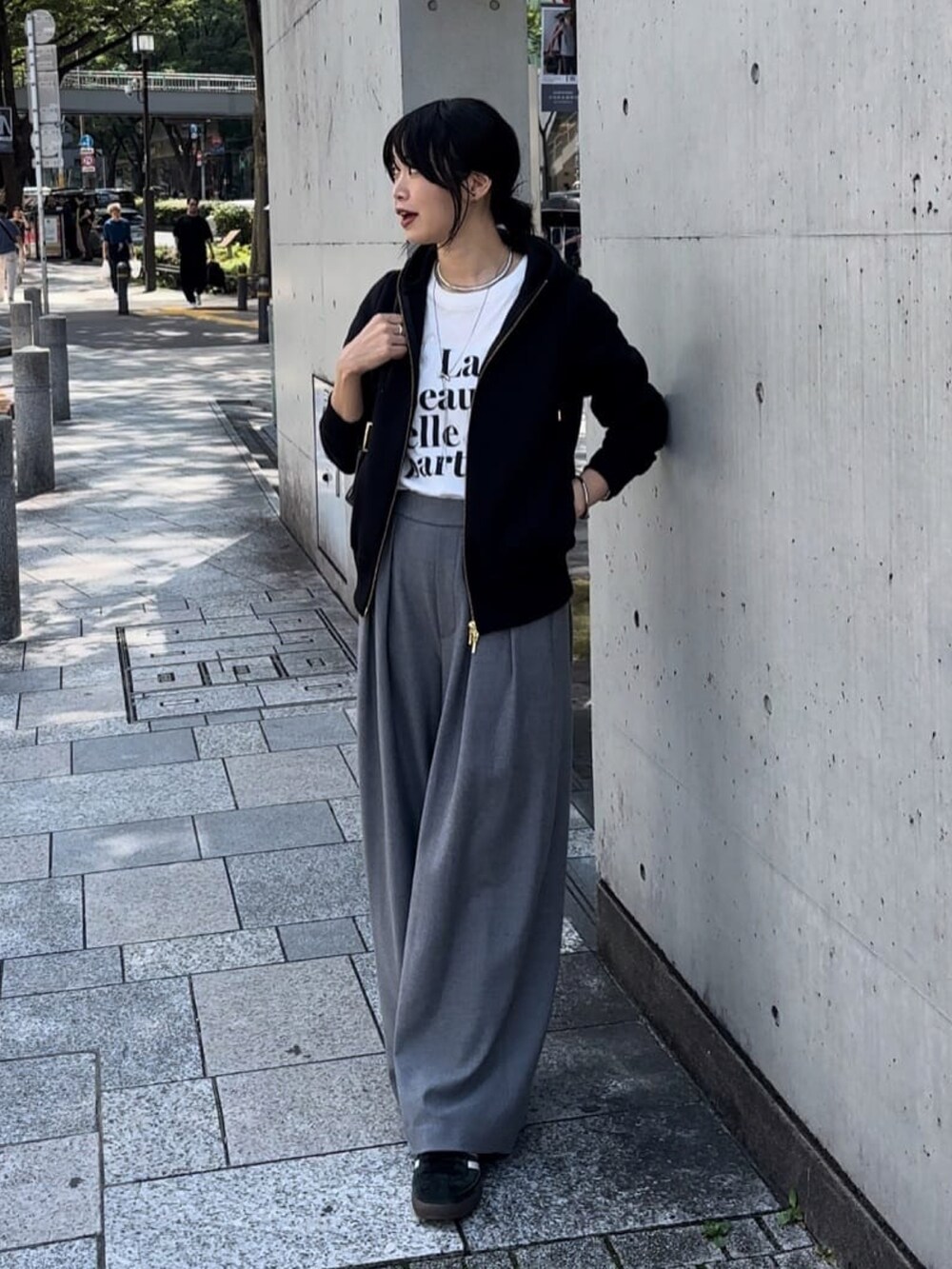 ブラック系のパーカー、グレー系のスラックス、ホワイト系のTシャツ/カットソーを着用したレディースの秋コーディネートの2枚目の写真