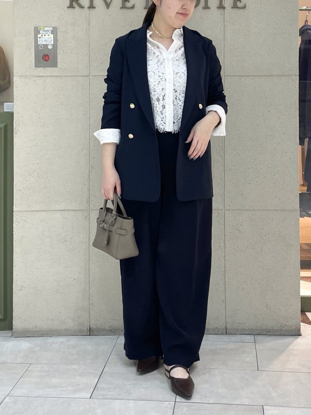 ブラウン系のその他シューズ、グレー系のトートバッグ、ホワイト系のシャツ/ブラウスを着用したレディースの春コーディネートの2枚目の写真