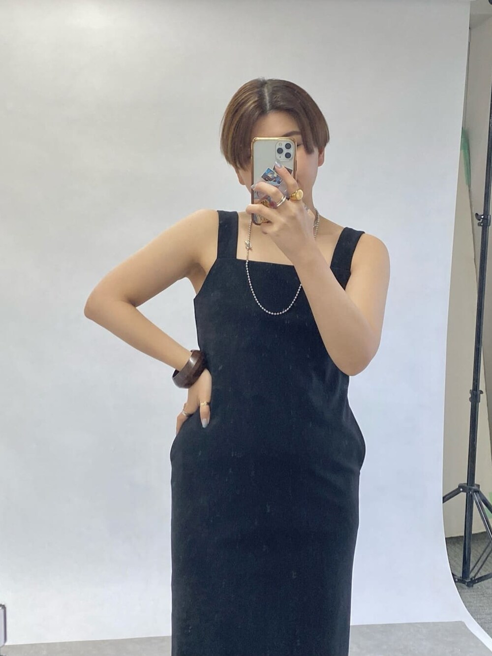 ブラック系のワンピース、シルバー系のサンダル、ベージュ系のシャツ/ブラウスを着用したレディースの春コーディネートの4枚目の写真