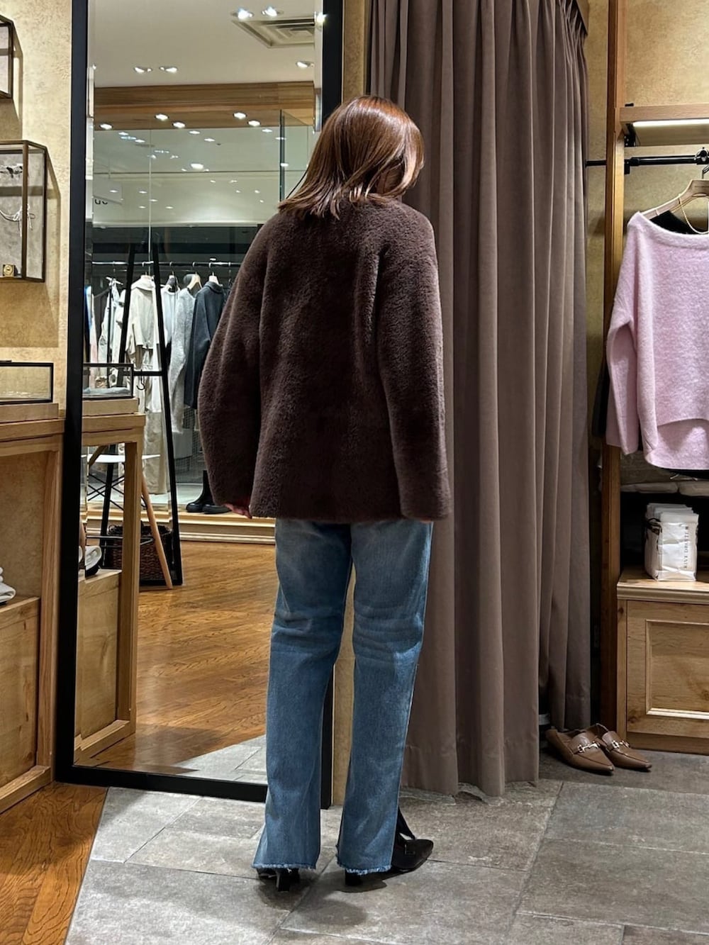 ホワイト系のニット/セーター、ブラウン系のカーディガン/ボレロ、ブルー系のデニムパンツを着用したレディースの秋コーディネートの3枚目の写真