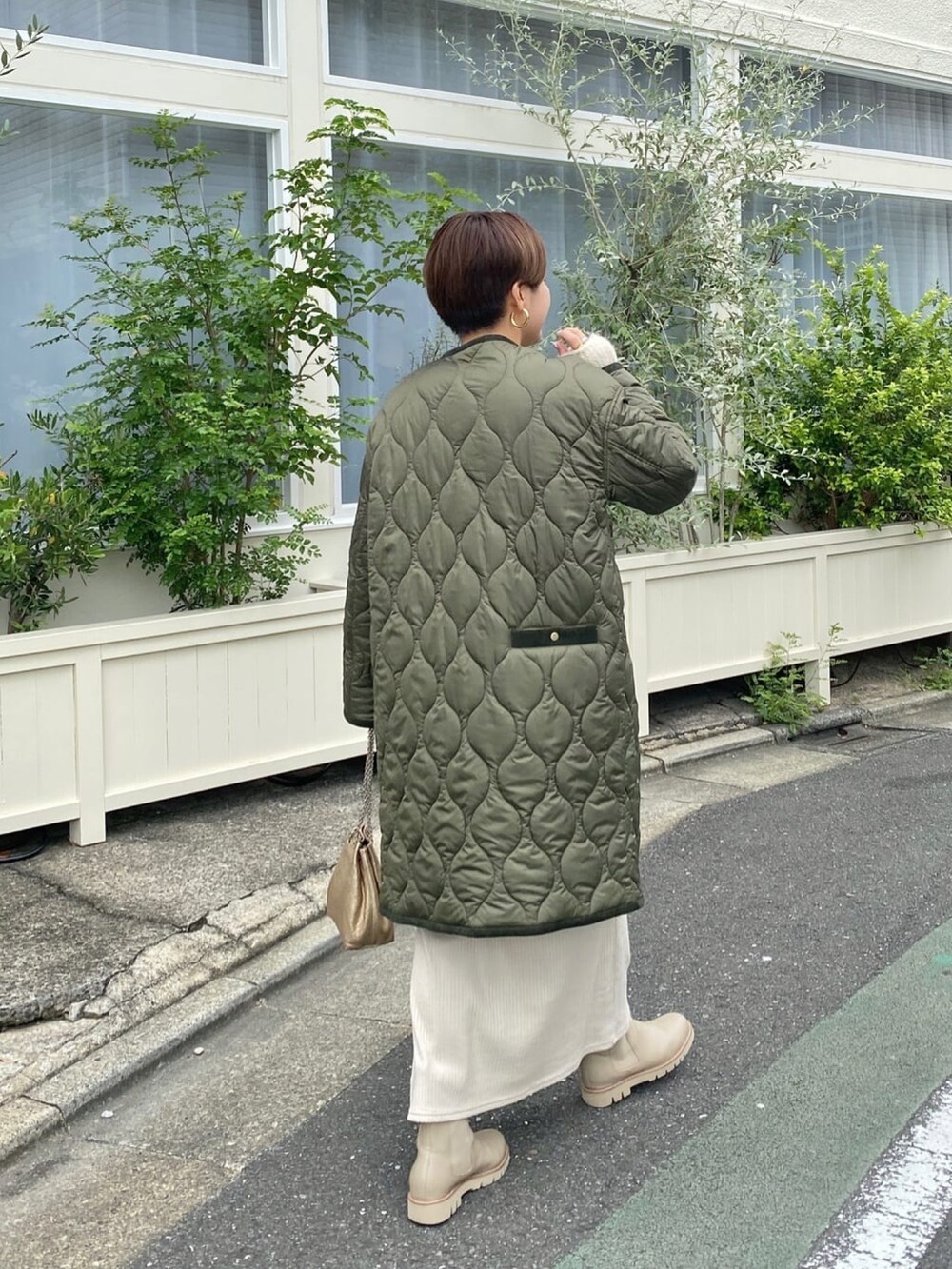 ベージュ系のワンピース、ベージュ系のニット/セーター、グリーン系のダウンジャケット/コートを着用したレディースの冬コーディネートの3枚目の写真