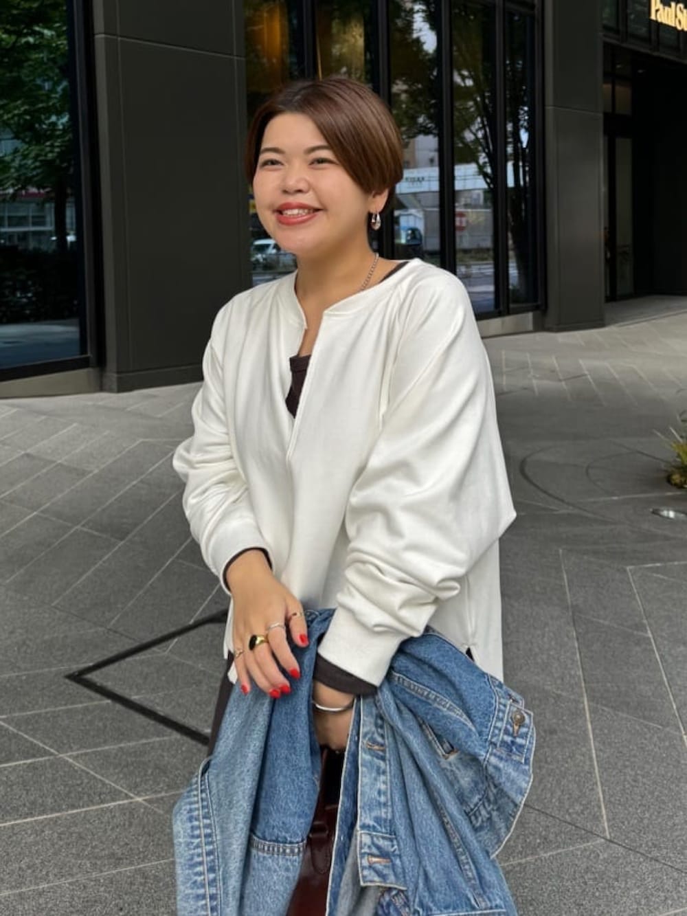 ホワイト系のスウェット、ブルー系のデニムジャケット、ブラック系のワンピースを着用したレディースの冬コーディネートの3枚目の写真