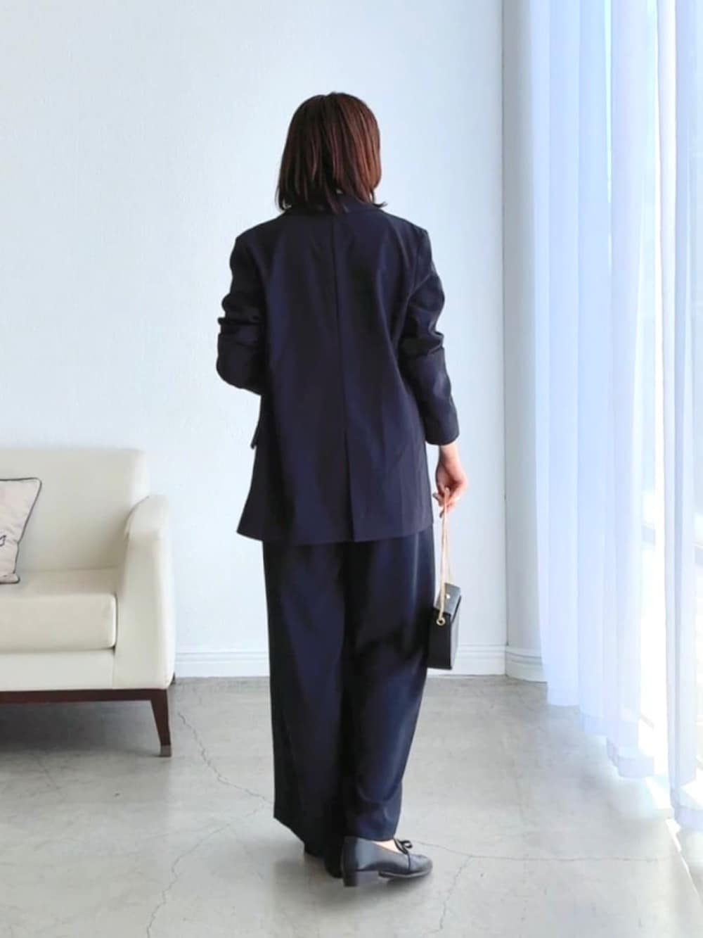 ベージュ系のシャツ/ブラウス、ブルー系のテーラードジャケット、ブルー系のスラックスを着用したレディースの冬コーディネートの2枚目の写真