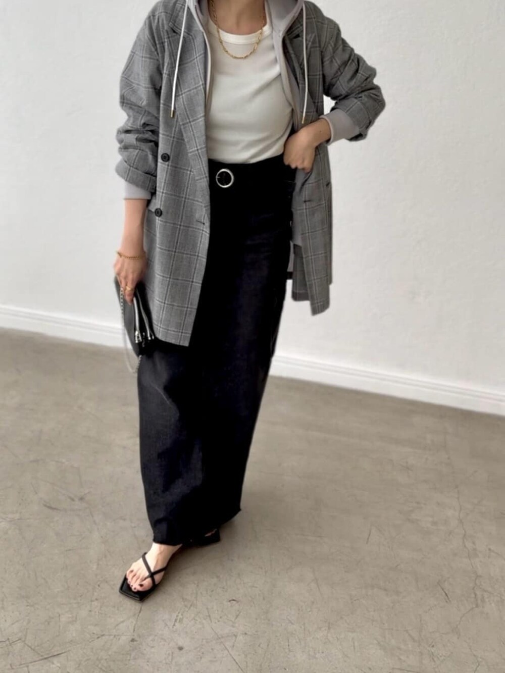 グレー系のテーラードジャケット、ブルー系のデニムスカート、ベージュ系のパーカーを着用したレディースの春コーディネートの4枚目の写真