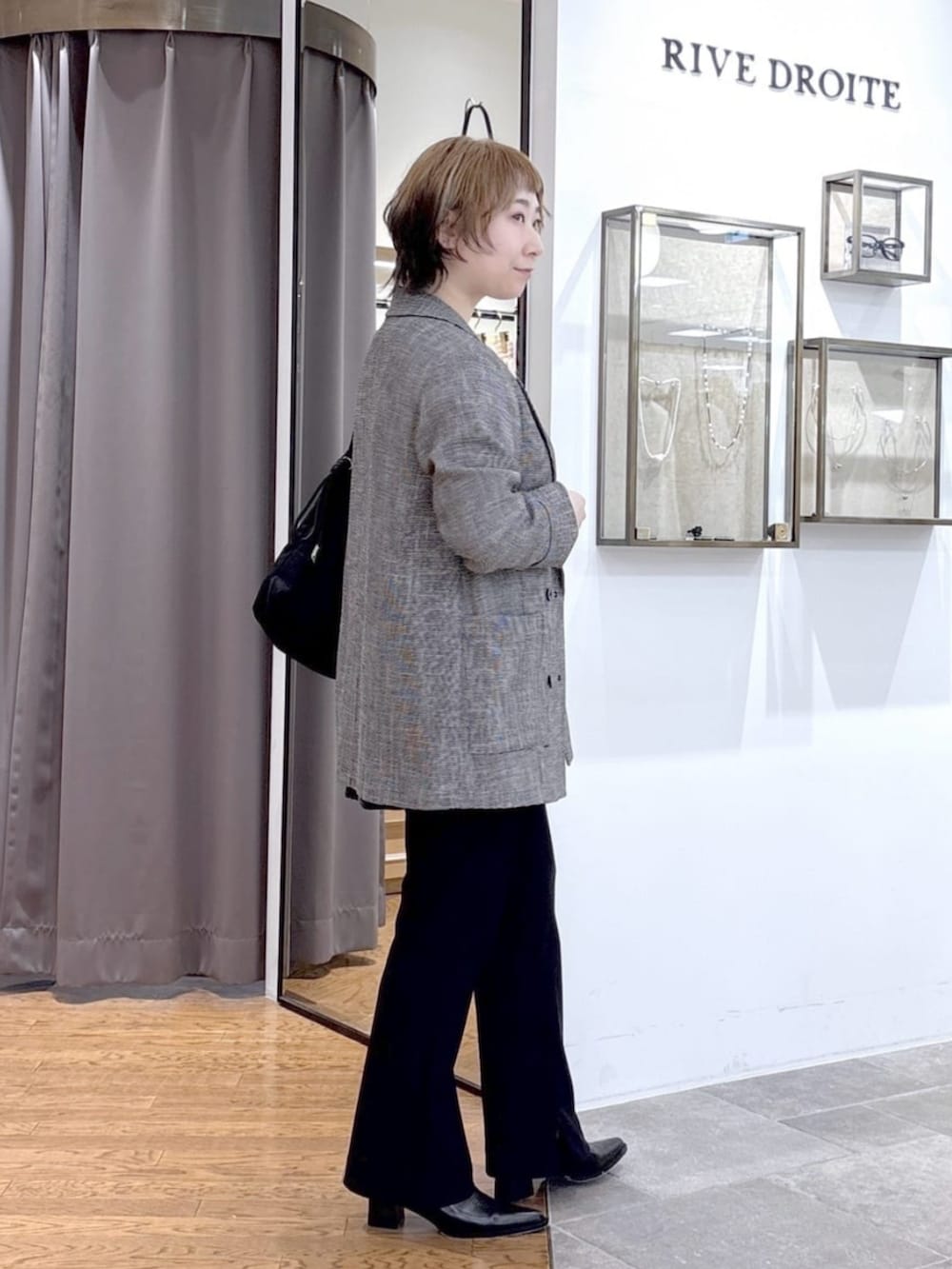 ブラック系のその他パンツ、ブラック系のテーラードジャケット、ブラック系のトートバッグを着用したレディースの春コーディネートの2枚目の写真