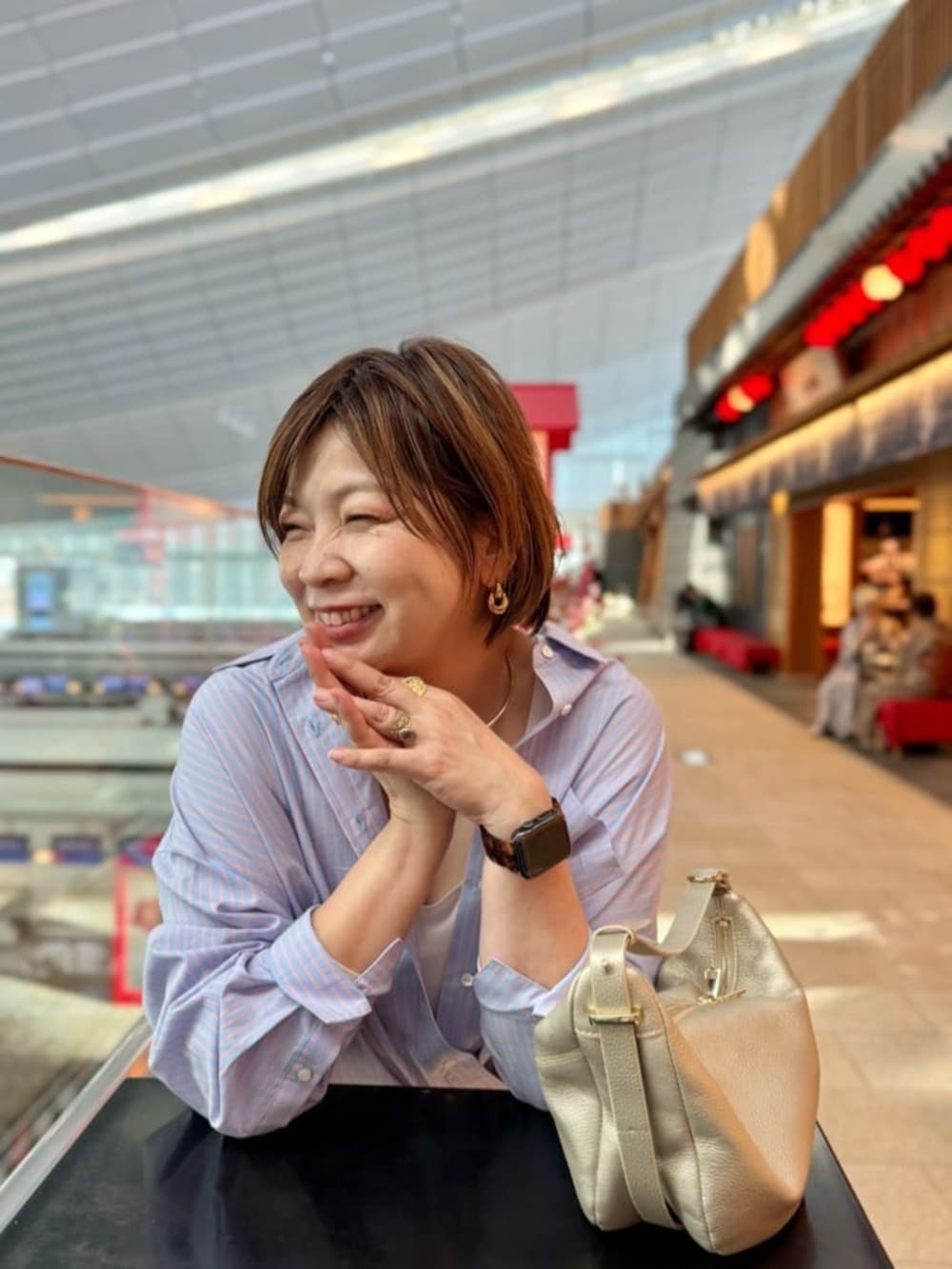 グレー系のトートバッグ、ホワイト系のデニムパンツ、ブラック系のその他シューズを着用したレディースの春コーディネートの3枚目の写真