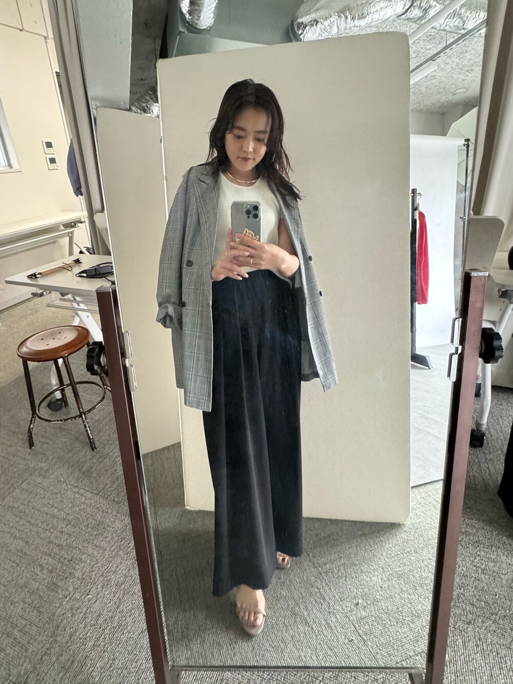 ホワイト系のスラックス、グレー系のサンダル、ホワイト系のニット/セーターを着用したレディースの春コーディネートの2枚目の写真